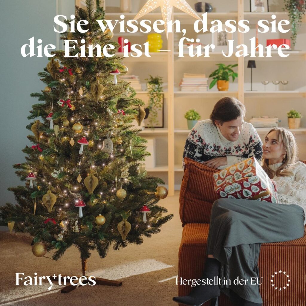 Matratzen kaufen Schweiz, Bettdecken kaufen Schweiz, Kopfkissen kaufen Schweiz Paar mit Geschenk vor der geschmückten FairyTrees Nordmanntanne FT29