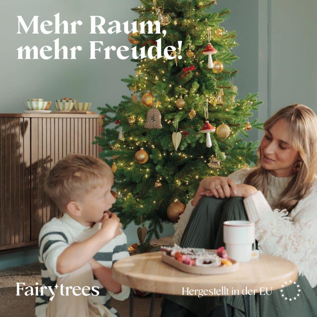Matratzen kaufen Schweiz, Bettdecken kaufen Schweiz, Kopfkissen kaufen Schweiz Mutter und Kind am Tisch vor der schlanken FairyTrees Nordmanntanne FT05